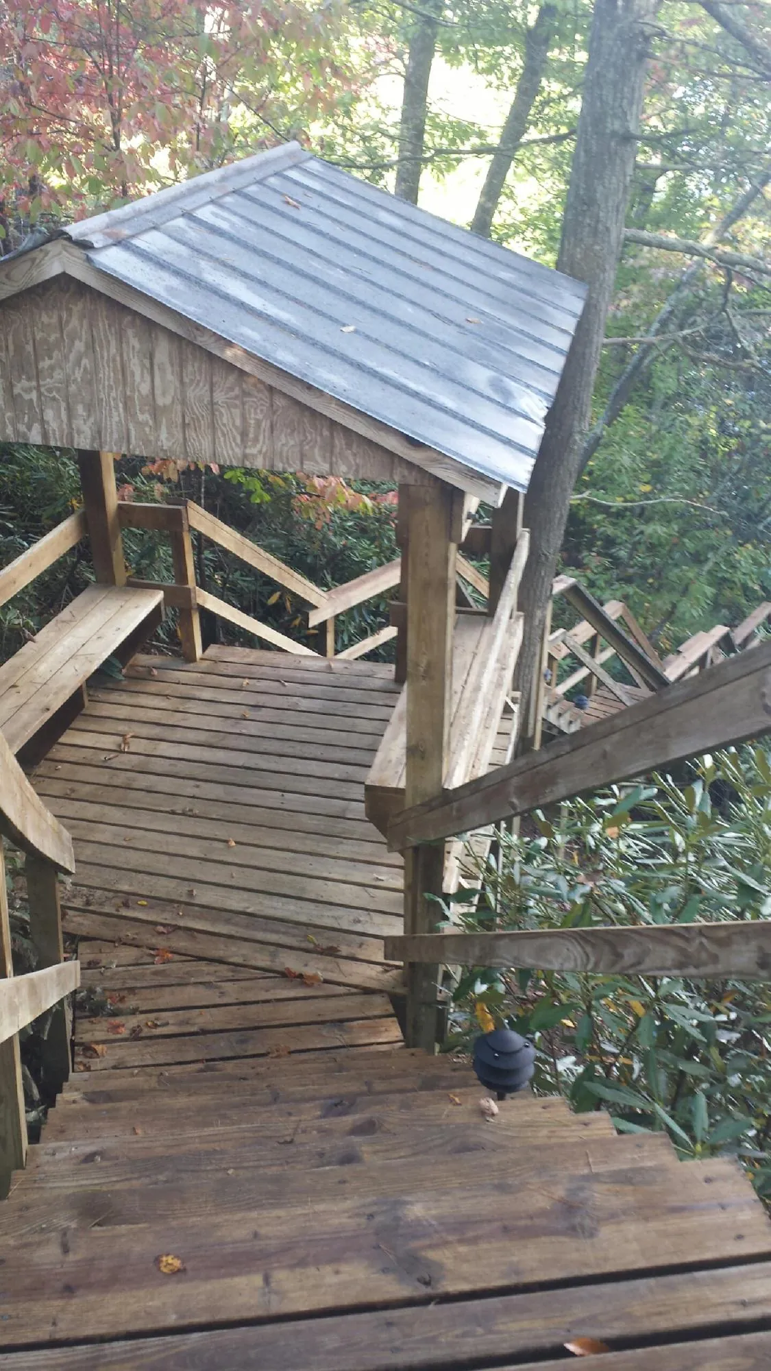 Metal roofed shelter over wooden steps on a wooded walkway — Skylight Repair & Installation work by our crew in Adams